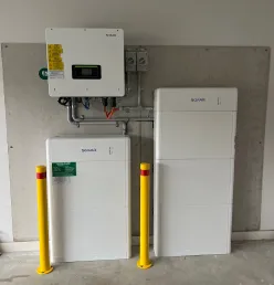 Indoor Sofar Solar battery system inverter above two white battery